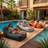 Poufs transat gris clair, anthracite et orange autour d'une piscine